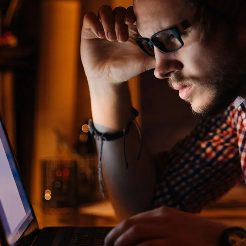 man focusing on computer screen